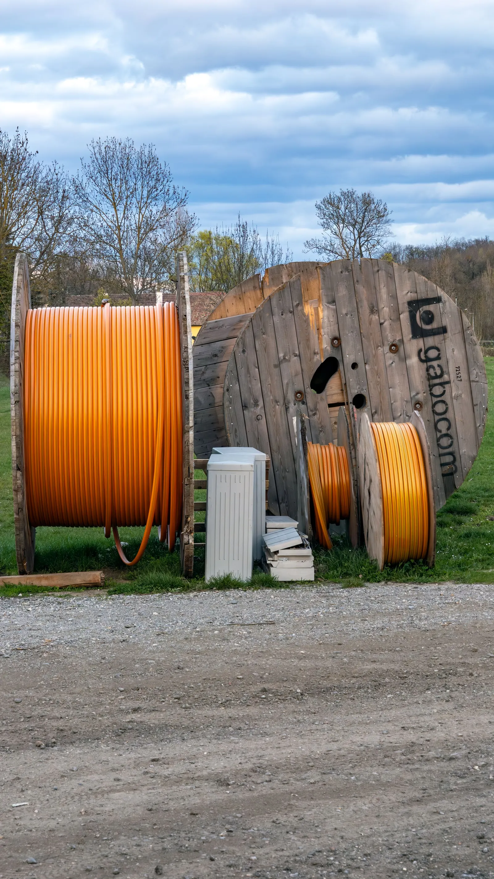 Drums of orange fibre duct and cable staged at a build site before a network roll-out